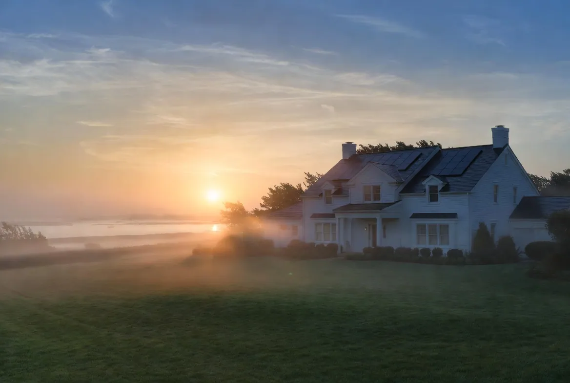 Long Island coastal home at sunrise with rooftop solar panels — ambient illustration for service-area planning